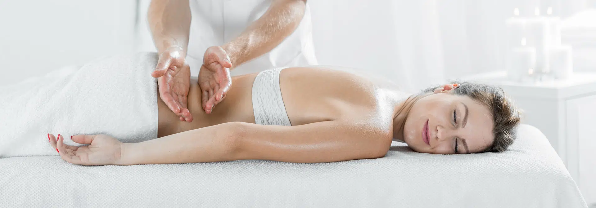 Woman receiving a full body massage on a white massage table